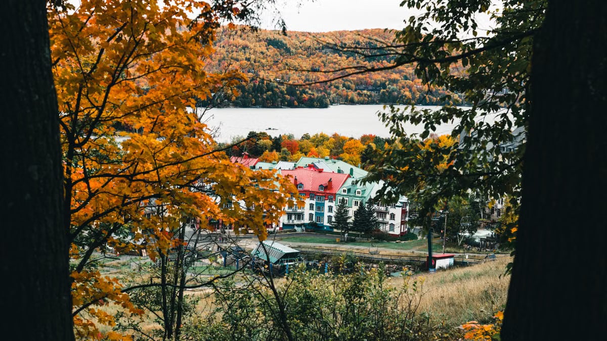 Autumn view of Mont-Tremblant with colorful trees and lake in the background.